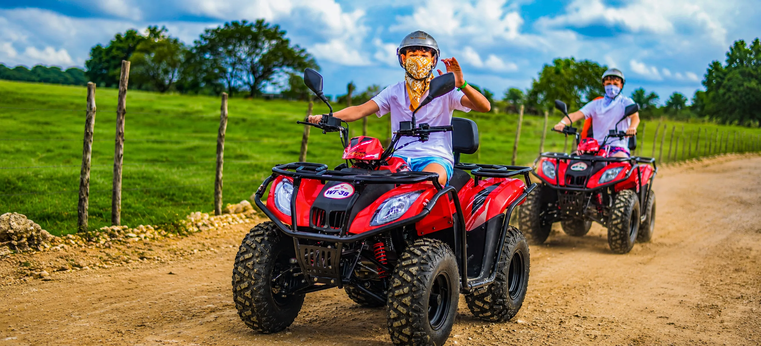 Guests riding red ATVs through muddy off-road trails during the Wild Trails Buggies adventure in Punta Cana, Dominican Republic.
